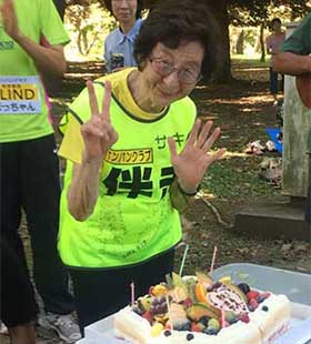 ケーキを前にピースサインのサッキーさん。